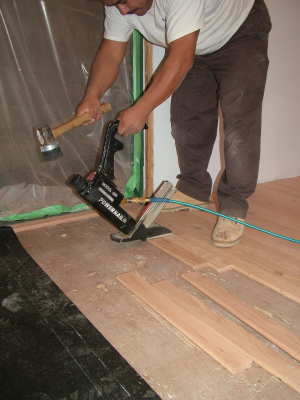 This air-powered nailer drives special nails through the tongue of the hardwood flooring. PHOTO CREDIT: Tim Carter