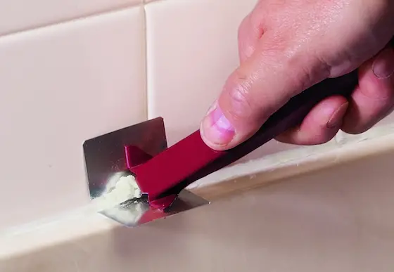 How do you clean caulking off after it has dried on a fiberglass tub?