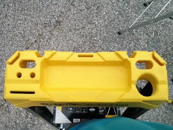 Look at all the places you can put tools. The large hole in the lower right is for a drill or impact driver chuck. The large center recess is for a gallon paint can. Photo credit: Tim Carter