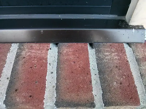 Water will obviously pour into the holes in the mortar joints in this brick window sill. It will also seep through where the mortar touches the brick. Photo Credit: © Tim Carter Builder