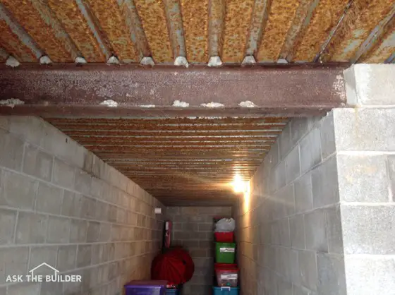 This basement under-porch area is damp and things stored here get moldy fast. Note the rusty metal ceiling. Photo credit: Sharon Geibel