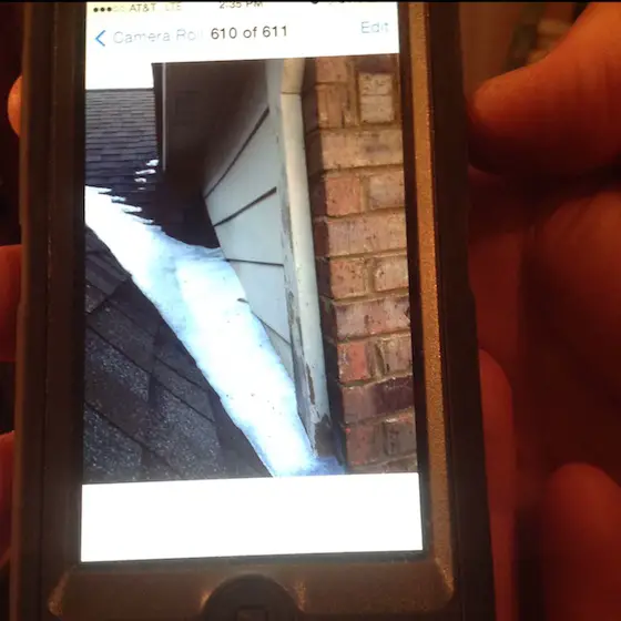 Here's a the ice dam at Karen's house. This is a photo. You're probably looking at the roofer's cell phone screen. Photo credit: Anonymous roofer and Karen Bloom