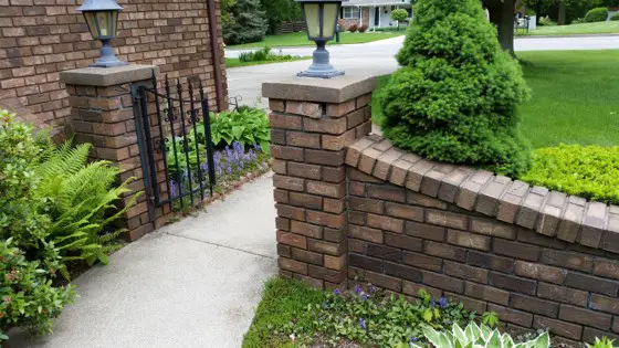 The brick just under the concrete cap to the right of the gate is falling apart. The challenge is to locate replacement brick to match. Photo Credit: Boyd Bronson