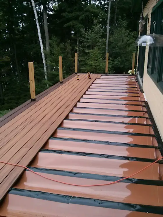 The Trex Transcend decking is being installed. Just as I say in the video, the Trex RainEscape sits BELOW the decking. Snow and ice don't collect on it, they sit on top of the decking. Photo credit: Tim Carter