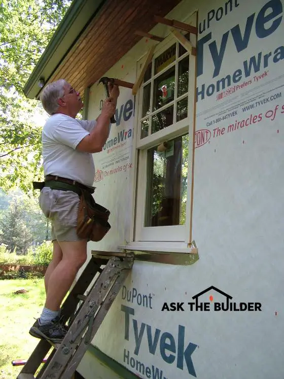 tim installing window on ladder