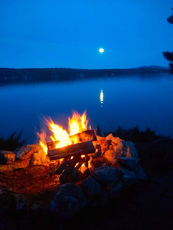 campfire by lake with full moon