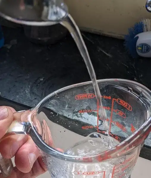 filling a measuring cup with water