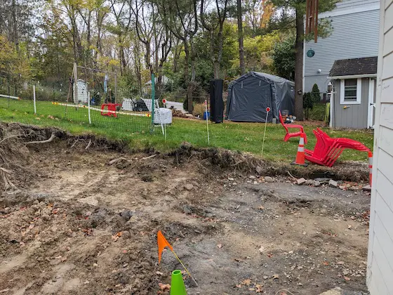 excavated earth in back yard tree stump removal