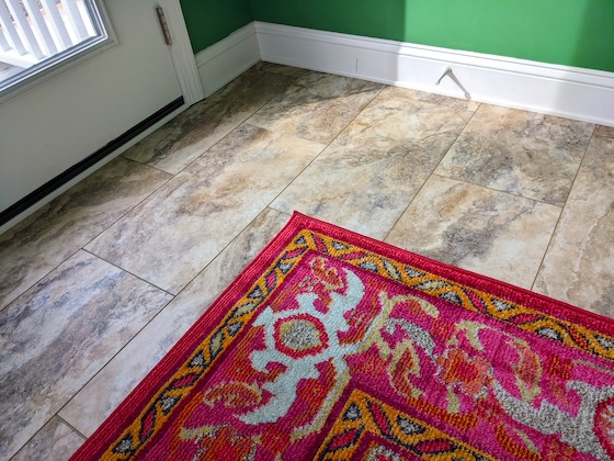 lvp flooring with red and gold area rug