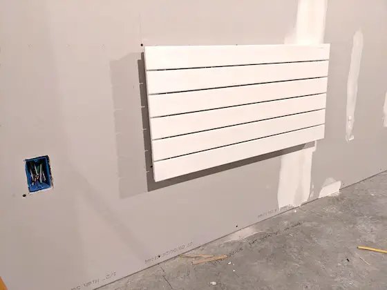 heavy runtal electric wall heater on drywall